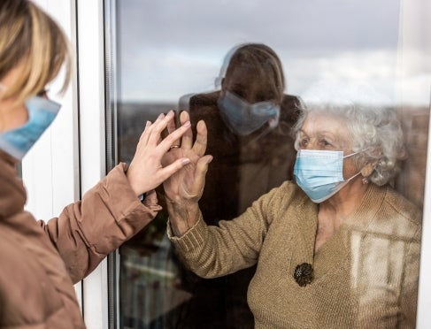 woman-visiting-her-grandmother-in-isolation-during-a-coronavirus-pandemic