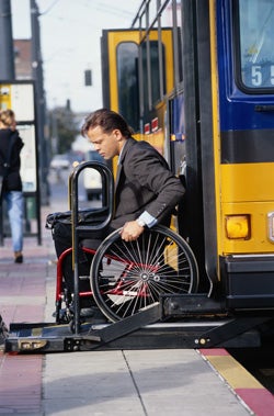 Man in wheelchair getting off bus