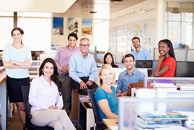 Large group of office workers standing and sitting in office