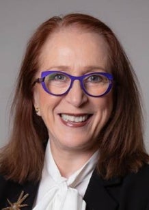 Woman with red long hair and glasses in business attire