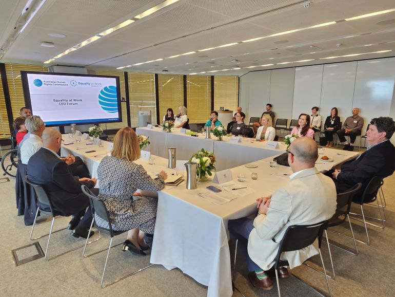 Participants seated around a large conference table at the Equality at Work CEO Forum with presentation screen at the front displaying the Equality at Work branding