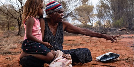 Yuendumu, NT Australie, February 15 2020 : Aborigines Warlpiri in the bush. Family, grandmother and granddaughter, after hunting honey ants