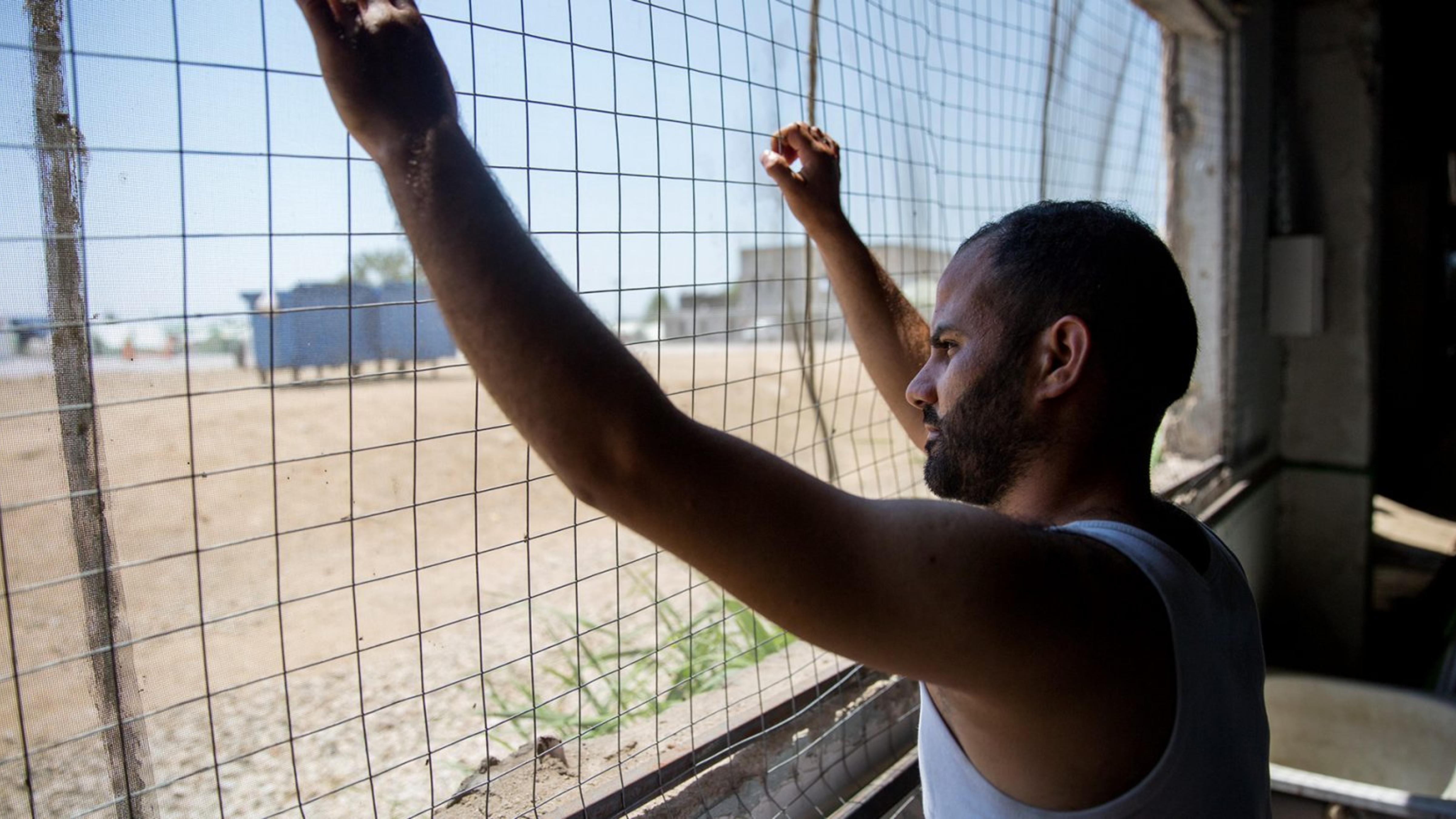 40 Years Refugee 4 Man behind mesh fencing