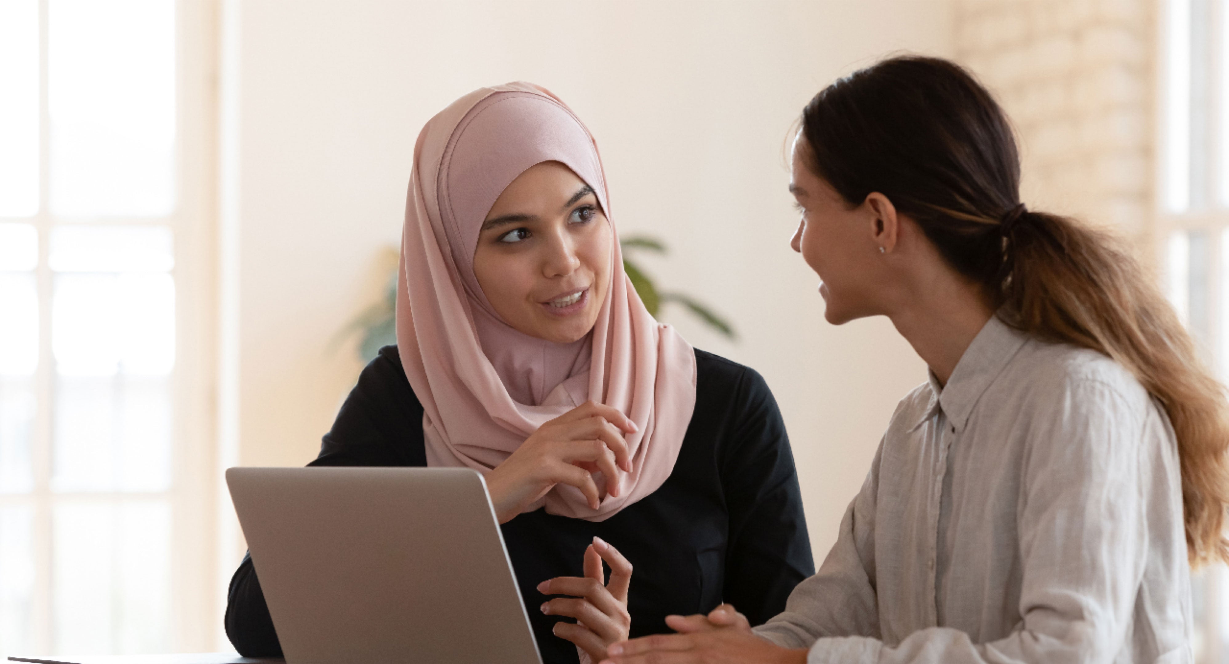 Multicultural businesswomen brainstorm cooperating at office meeting.