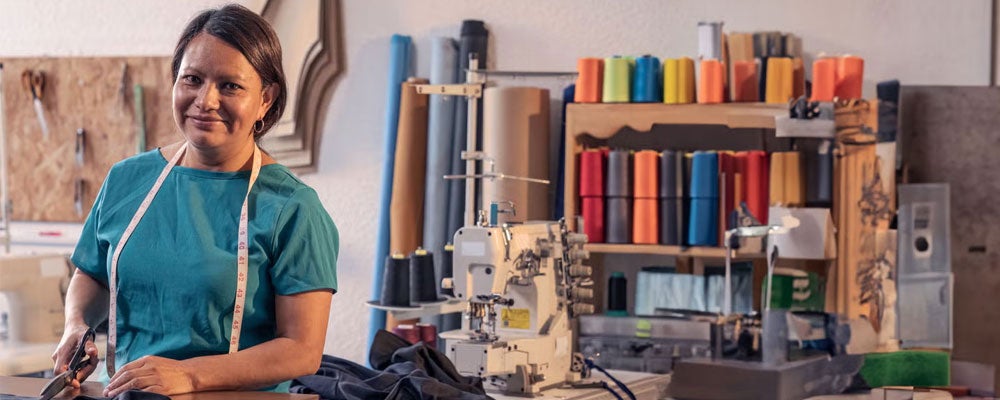 Beautiful woman working in the tailoring industry poses in front of the camera for a portrait.