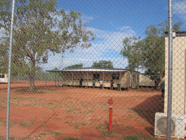 People in detention using outdoor telephones, Curtin IDC