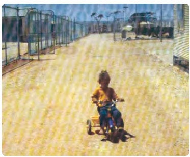 Child riding a bike in detention centre. (c) Natalie Sheard
