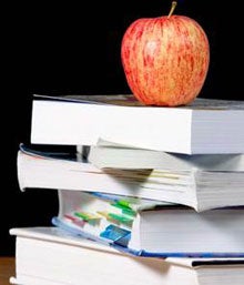 An apple on top of a bunch of books
