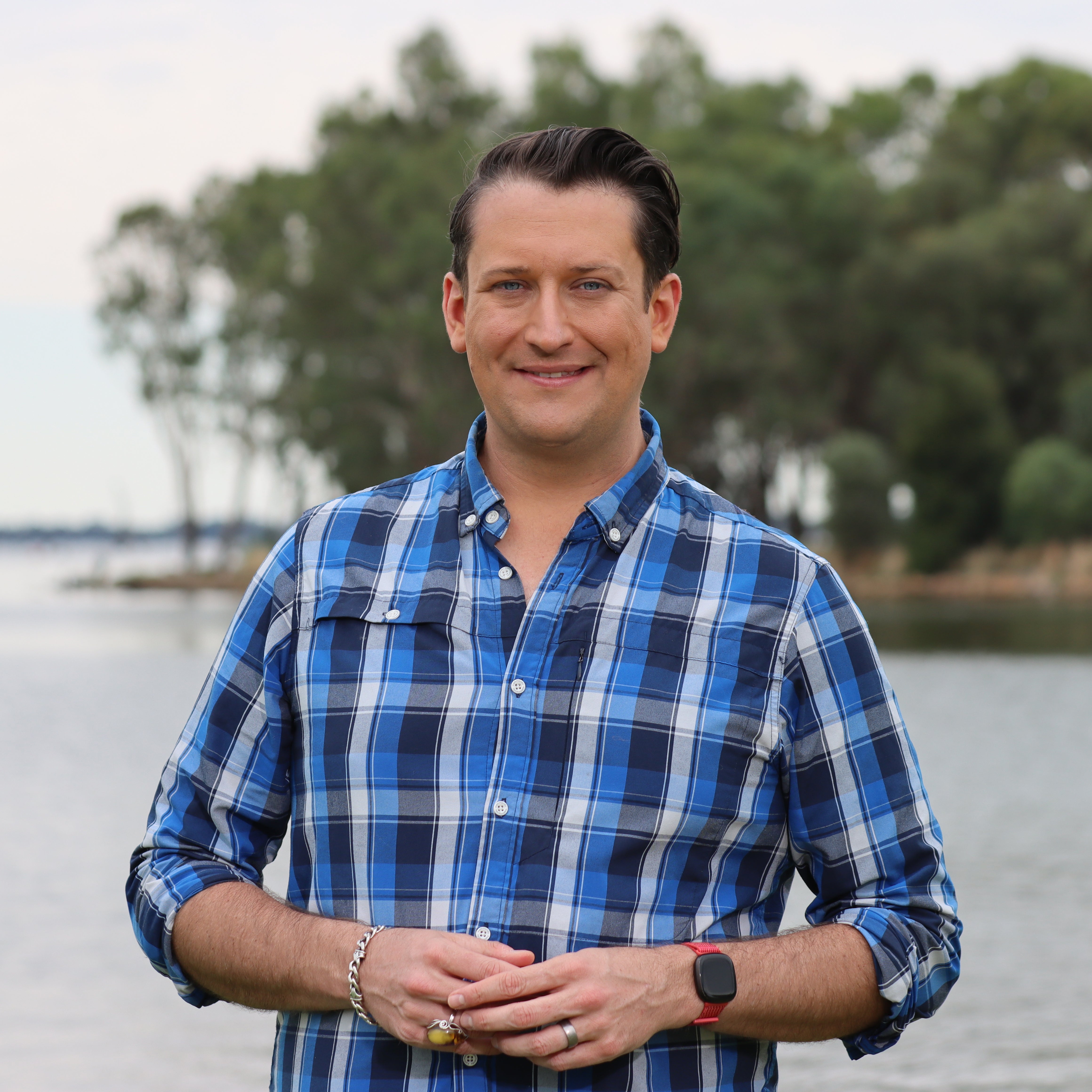 Man in blue check shirt smiling