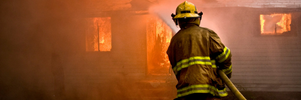Fireman hosing down a burning home