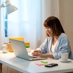 An asian lady working from home on her desk
