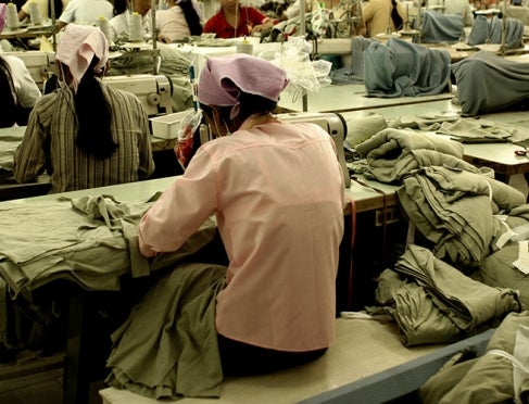 A woman sits in a sweatshop