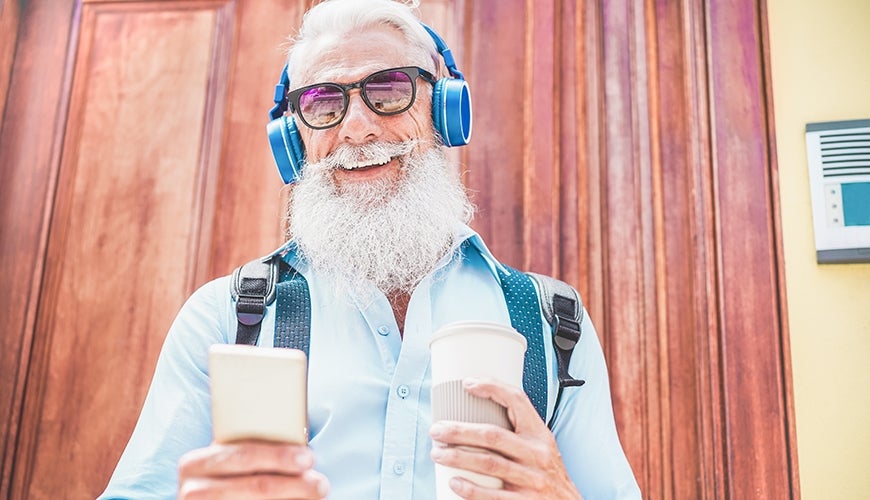 older man enjoying music and drinking coffee