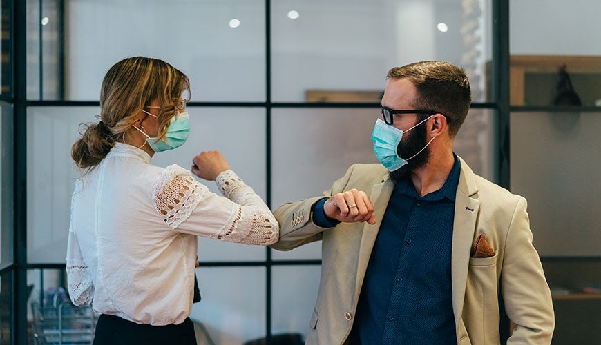 Business people greet during pandemic with elbow bump