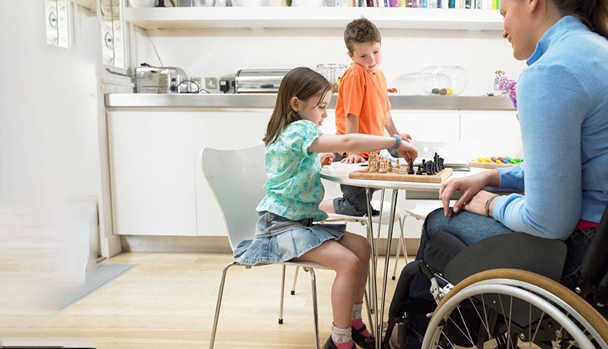 Mother with disability playing chess with her children