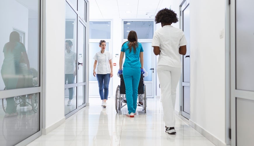Three medical staff walking down a hallway