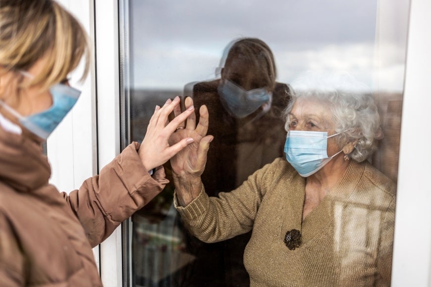 woman-visiting-her-grandmother-in-isolation-during-a-coronavirus-pandemic