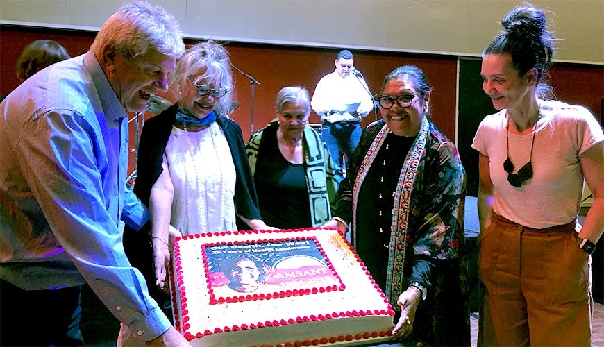 June Oscar and presenters at AMSANT smiling at conference cake