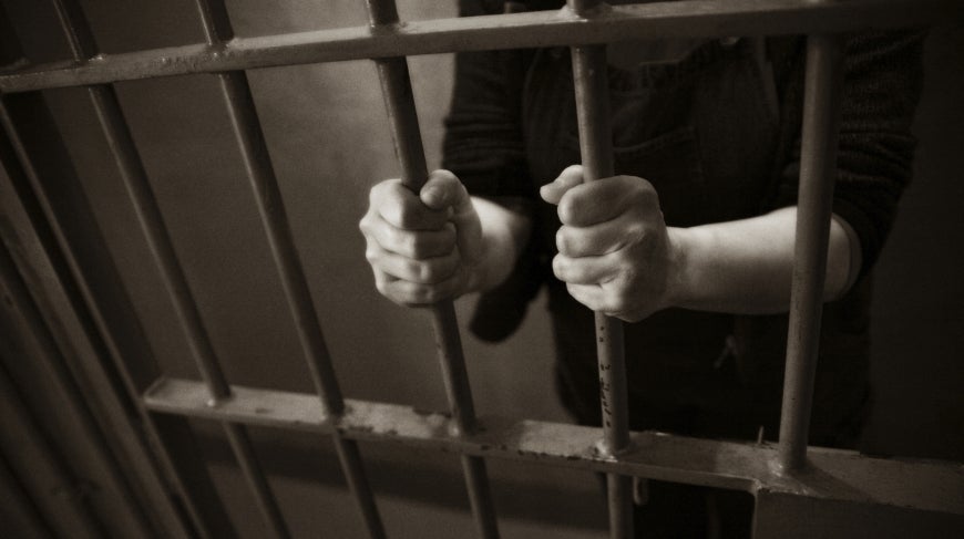 Image of person in a prison cell