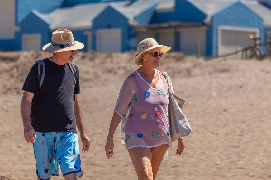 older couple walking along the sand
