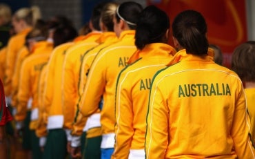 The Australian women's football team, standing with their backs to the camera.