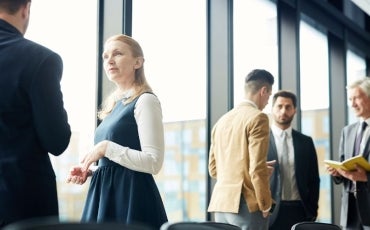 A woman standing near a window in a corporate office setting