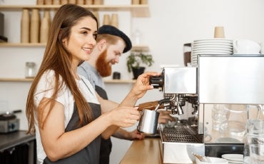 Female and male baristas in cafe