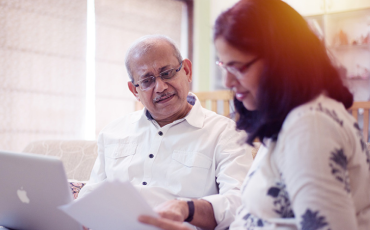 older man looks over documents with adult daughter