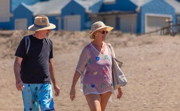 older couple walking along the sand