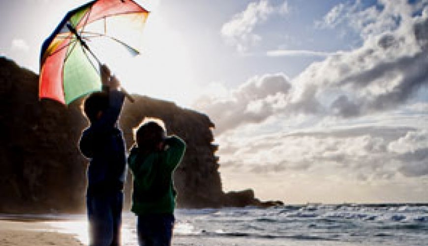 Photo: Children on a beach with an umbrella