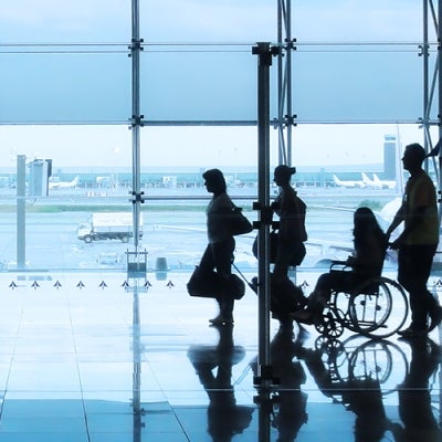 family including person using a wheelchair walking through an airport