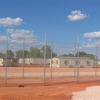 Immigration detention centre in dusty field