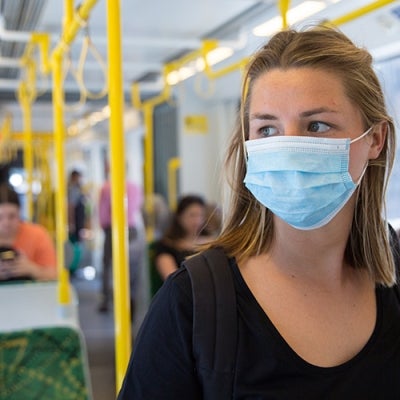 Woman on train in mask