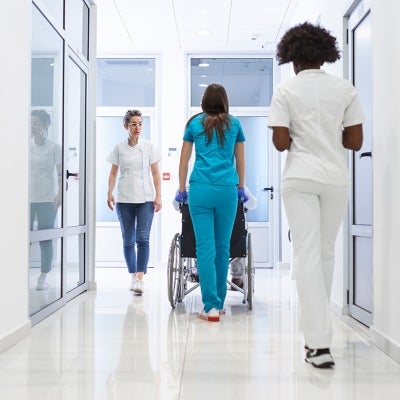 Three medical staff walking down a hallway