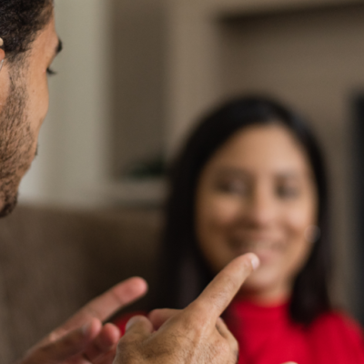 A person with a hearing aid engaging in a conversation with another person. 